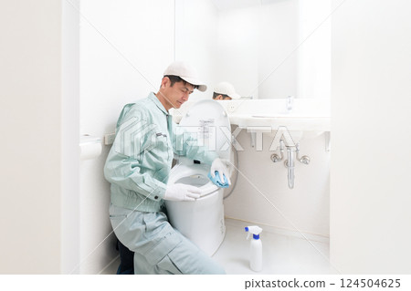 Male staff in work clothes cleaning the toilet 124504625