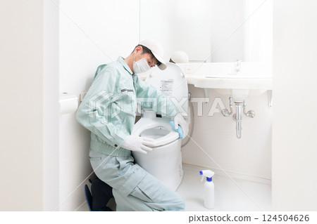 Male cleaner cleaning the toilet Male cleaner cleaning the toilet 124504626