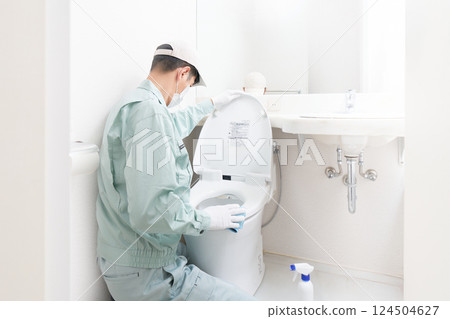 Male cleaner cleaning the toilet Male cleaner cleaning the toilet 124504627