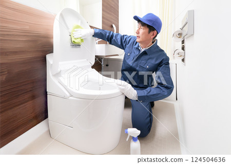 一名身穿工作服的男子正在清潔廁所 124504636