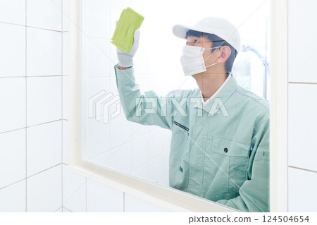 Male staff in work clothes cleaning the shower room Male staff in work clothes cleaning the shower room 124504654