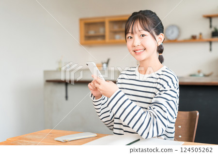Elementary school student, junior high school girl, child studying at home using smartphone Elementary school student, junior high school girl, child studying at home using smartphone 124505262