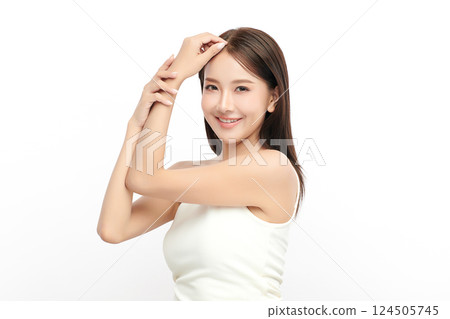 A beautiful young Asian woman with clean, fresh skin against a white background. Skincare, facial treatment, cosmetology, beauty, and spa. An elegant portrait of an Asian woman. 124505745