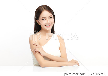 A beautiful young Asian woman with clean, fresh skin against a white background. Skincare, facial treatment, cosmetology, beauty, and spa. An elegant portrait of an Asian woman. 124505749