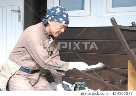 Middle-aged man painting a sign (close-up) 124505877