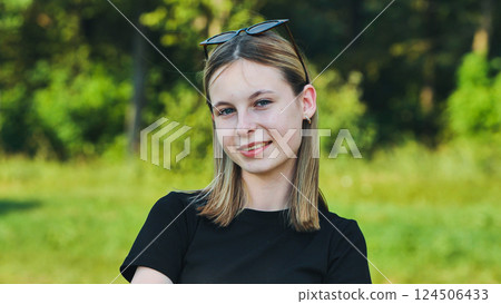 Happy blonde high school student wearing sunglasses, having fun in the park during a school break 124506433