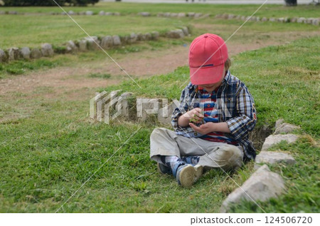 Young Child Exploring Nature in a Park Setting 124506720