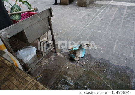 破桶、舊清潔工具和垃圾桶躺在巷子裡 124506742