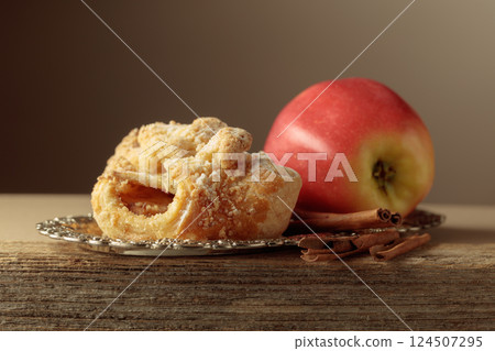 Viennese strudel with apple and cinnamon on old wooden table. Viennese strudel with apple and cinnamon on old wooden table. 124507295