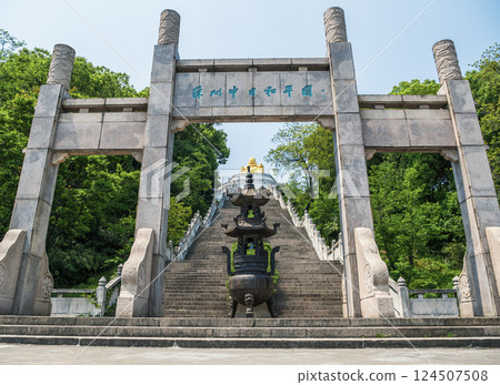Magnificent stairs lead to golden Buddha statue in serene mountain landscape on a sunny day. Magnificent stairs lead to golden Buddha statue in serene mountain landscape on a sunny day. 124507508