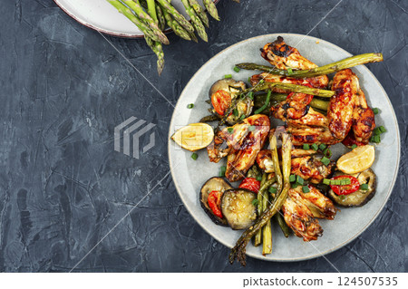 Grilled chicken wings with green asparagus. 124507535