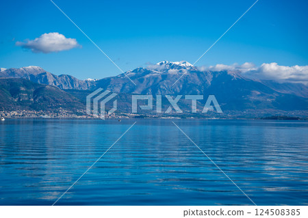 Bay of Kotor in Montenegro and the top of high snow-capped mountains, small settlements on the coast and the bright blue waters of the Adriatic Sea. 124508385