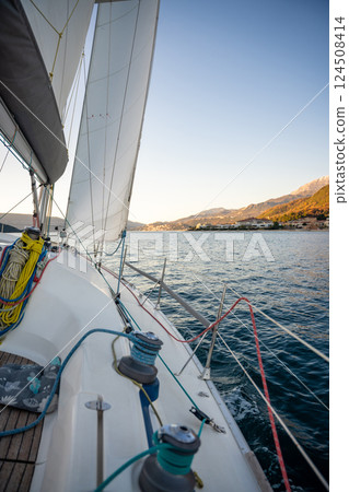 Yacht sailing in Adriatic sea. Close-up view of the deck, mast and sails. Yachting concept Yacht sailing in Adriatic sea. Close-up view of the deck, mast and sails. Yachting concept 124508414