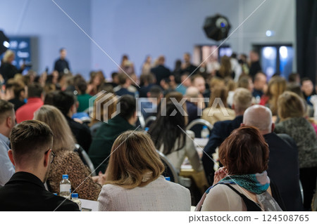 Audience gathered at conference event in a focused and engaged setting Audience gathered at conference event in a focused and engaged setting 124508765
