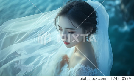 Bride in wedding dress standing on cliff by sea 124510559
