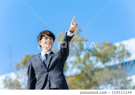 Businessman pointing at blue sky Businessman pointing at blue sky 124511144