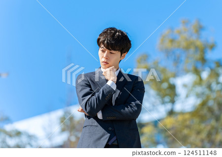 Businessman thinking under blue sky Businessman thinking under blue sky 124511148