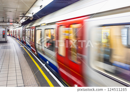 London Underground Train in Motion at Platform During Arrival 124511285