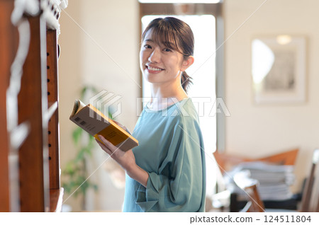 在書架前看書的女人 124511804