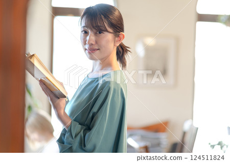 在書架前看書的女人 124511824