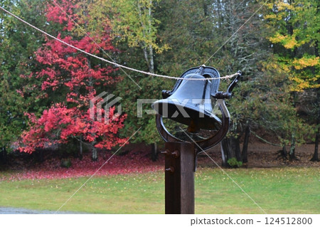 A bell that tells you when it's raining, with autumn leaves in the background 124512800