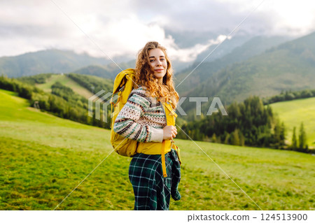 Cute traveler in hat takes selfie against backdrop of green mountain landscapes. Concept of freedom 124513900