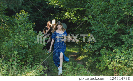 School friends gathering firewood in a lush forest, preparing for a bonfire and enjoying their time together in nature School friends gathering firewood in a lush forest, preparing for a bonfire and enjoying their time together in nature 124514728