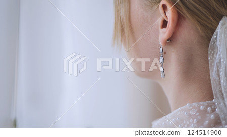 Close up of a bride's elegant earrings, adding a touch of sparkle to her wedding day look Close up of a bride's elegant earrings, adding a touch of sparkle to her wedding day look 124514900