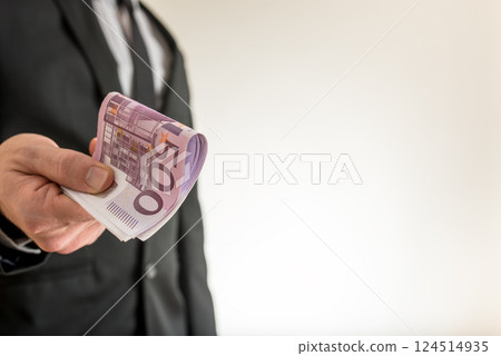 Businessman offering you five hundred Euro bills 124514935