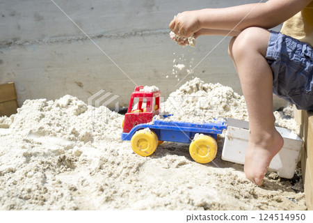 Boy Playing with his Truck Toy at the Beach Sand 124514950