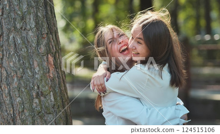 Two high school girl friends hugging and laughing. Two high school girl friends hugging and laughing. 124515106