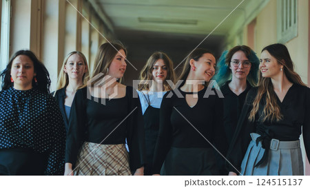 Female high school or university students chatting and walking together in the school hallway during a break Female high school or university students chatting and walking together in the school hallway during a break 124515137