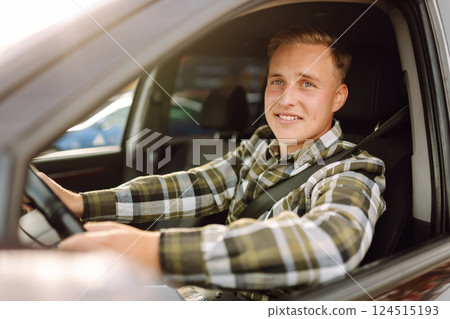 Happy man feeling comfortable sitting on driver seat in car. Lifestyle concept. Car sharing concept. Happy man feeling comfortable sitting on driver seat in car. Lifestyle concept. Car sharing concept. 124515193