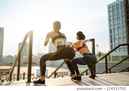 Two women in sportive clothes have fitness day outdoors together. Active life, healthy lifestyle. Two women in sportive clothes have fitness day outdoors together. Active life, healthy lifestyle. 124515702