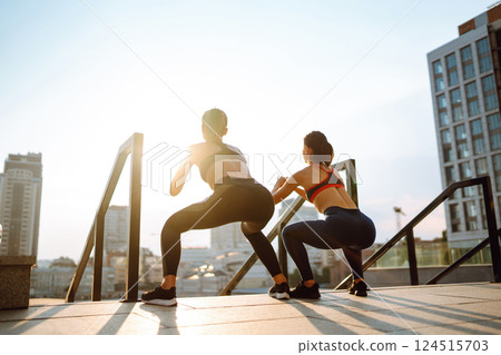 Two women in sportive clothes have fitness day outdoors together. Active life, healthy lifestyle. Two women in sportive clothes have fitness day outdoors together. Active life, healthy lifestyle. 124515703