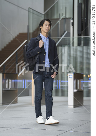 A businessman in his 30s walking with a business backpack A businessman in his 30s walking with a business backpack 124515792