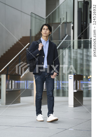 Young businessman walking with a business backpack 124516932