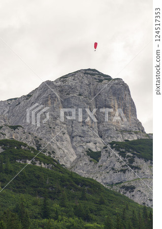 Paraglider flying over the Angerstein mountain, Alps, Gosau, Gmunden district, Upper Austria federal state, summer day 124517353