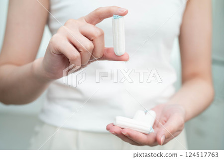 Asian woman holding cotton tampons for hygiene menstrual period cycle protection. 124517763