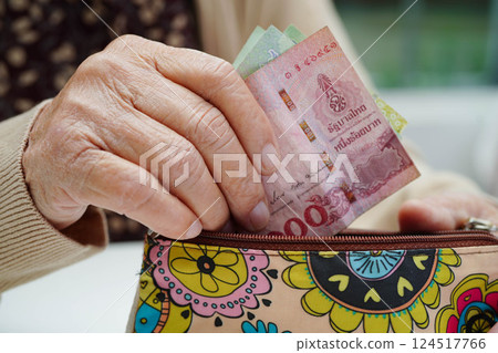 Asian senior or elderly old lady woman holding counting coin money in bag. Poverty, saving problem in retirement. Asian senior or elderly old lady woman holding counting coin money in bag. Poverty, saving problem in retirement. 124517766
