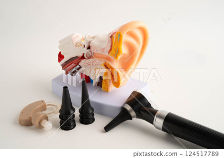 Otoscope with ear model for otolaryngologist or ENT physician doctor examining senior patient ear, hearing loss problem. 124517789