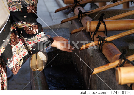 People wash their hands cleansing ritual at Temizuya water pavilion before enter shrine in Japan. 124518104