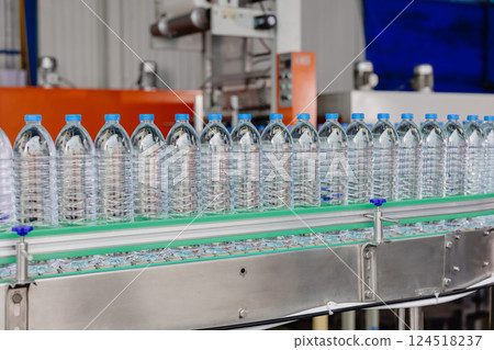 Drinking water production line on conveyor belt. PET Plastic water bottles in drink factory Drinking water production line on conveyor belt. PET Plastic water bottles in drink factory 124518237