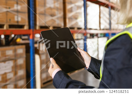 closeup warehouse worker using modern tablet computer wireless digital technology device in logistic 124518251