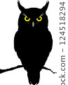 A black owl with yellow eyes 124518294