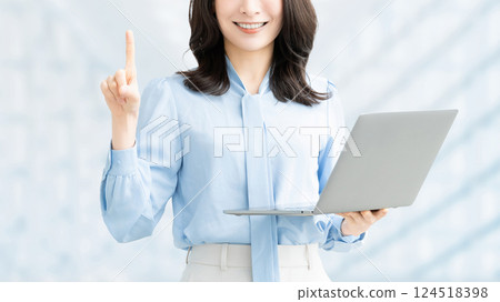A smiling woman holding a computer and giving directions A smiling woman holding a computer and giving directions 124518398