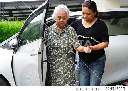 Caregiver help Asian elderly woman disability patient get in her car. 124518625