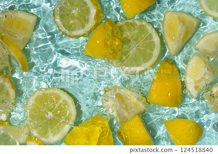 Refreshing turquoise citrus background with floating yellow lemon pieces 124518840