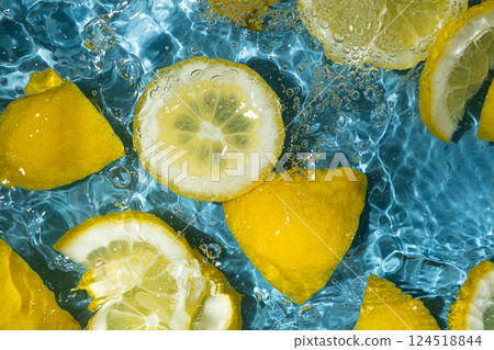 Juicy lemon background of halves and slices of fresh lemons in water. 124518844