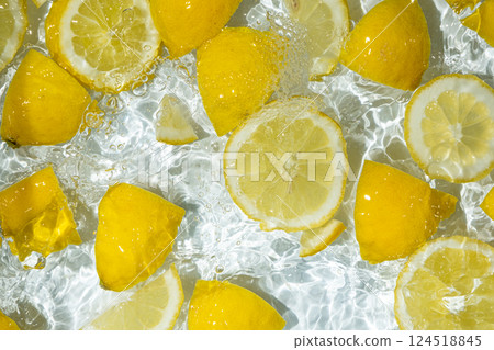 Slices of fresh lemons in water, splash of water, top view. 124518845